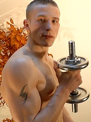 Oiled boy pumps up his biceps